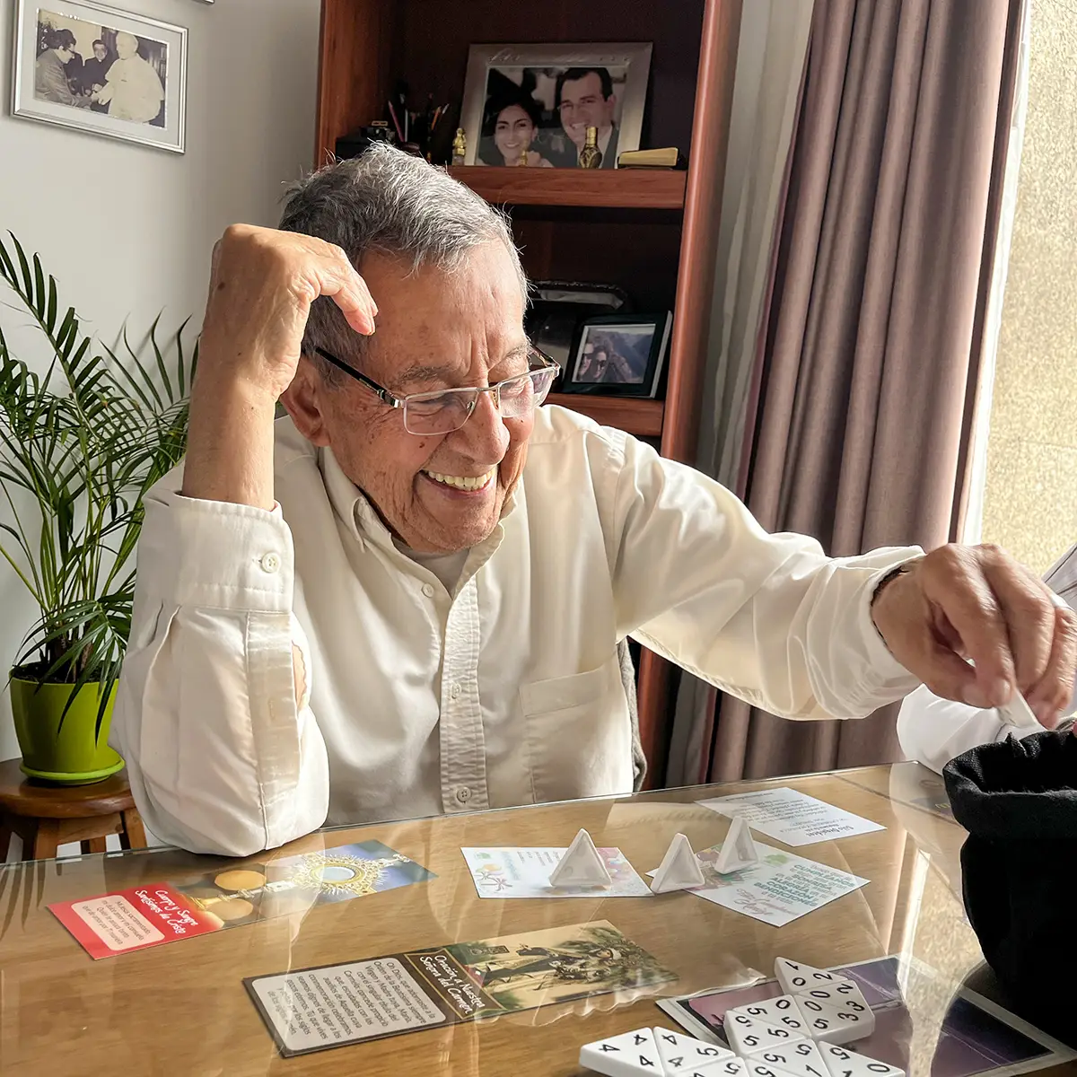 Una residente disfruta una actividad de mesa en su habitación privada en San Juan.
